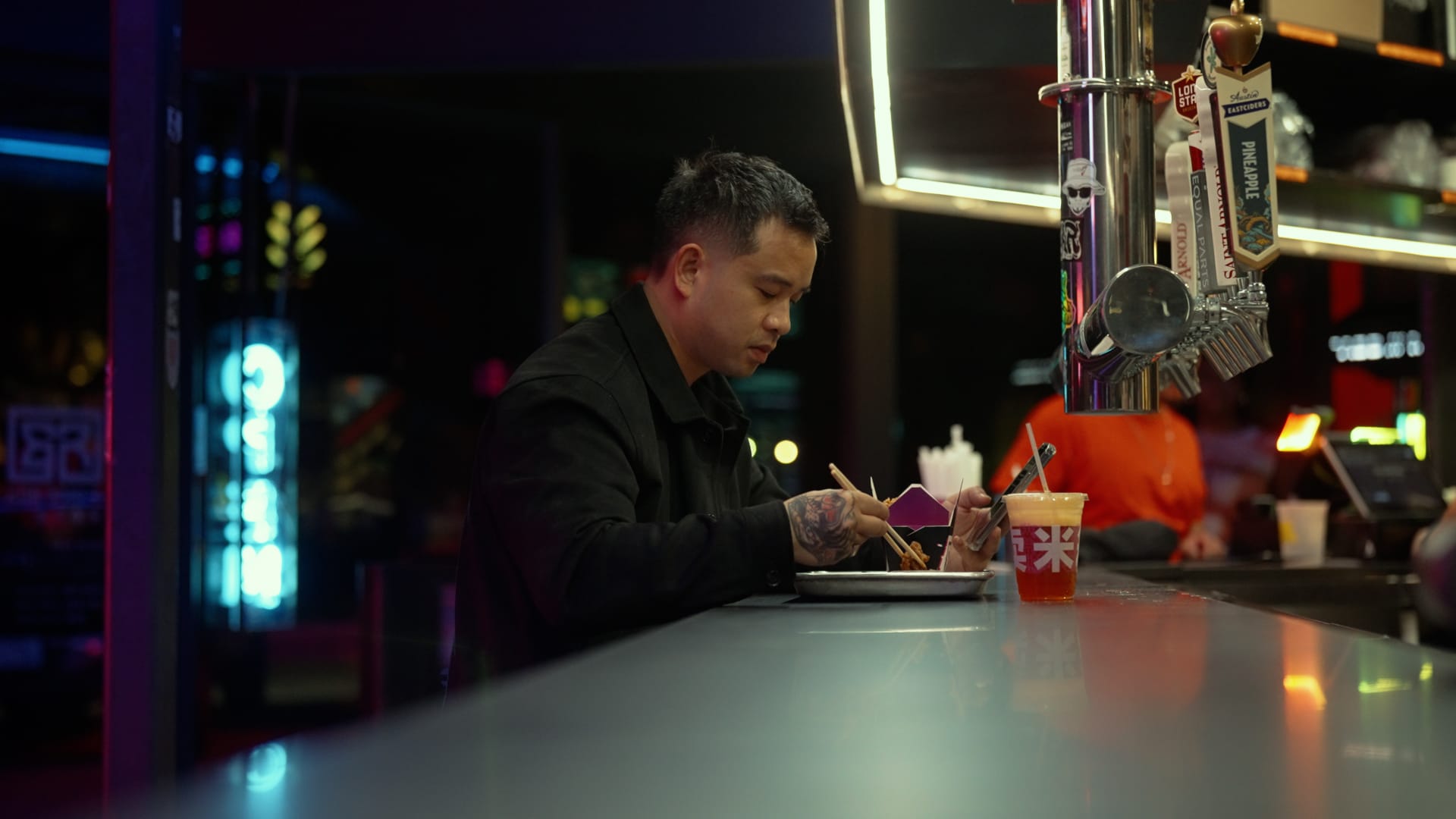 Man sits at bar at Rice Box with food and nitro tea